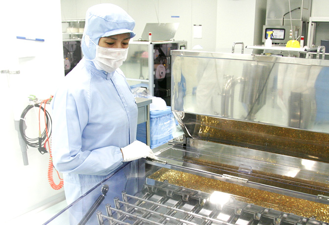 工廠人員檢視水滴軟膠囊的製造
